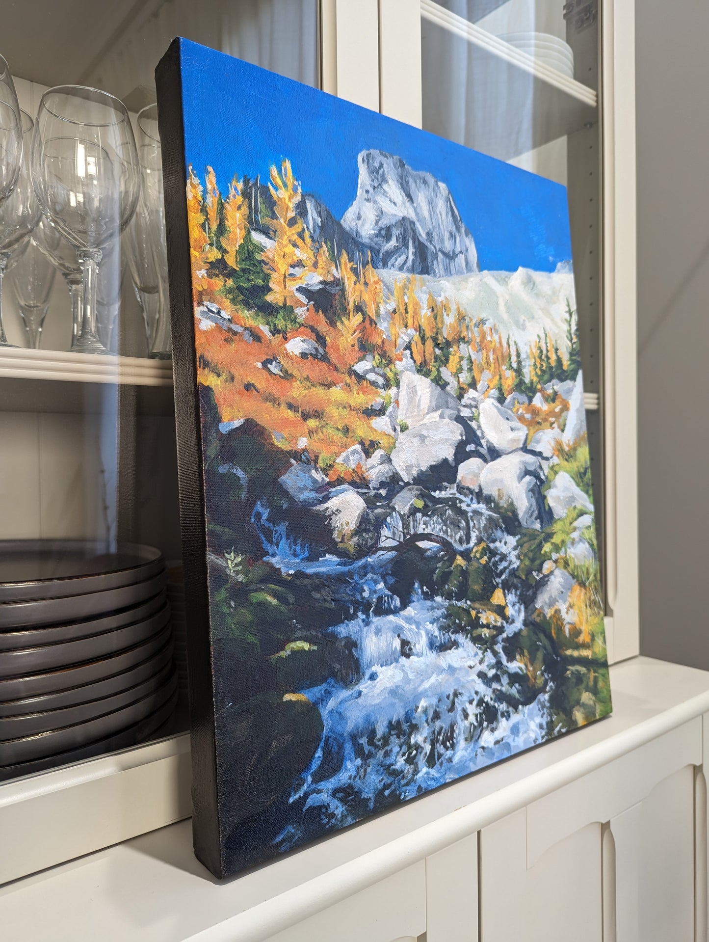 acrylic painting of a mountain surrounded by larches and stream of water